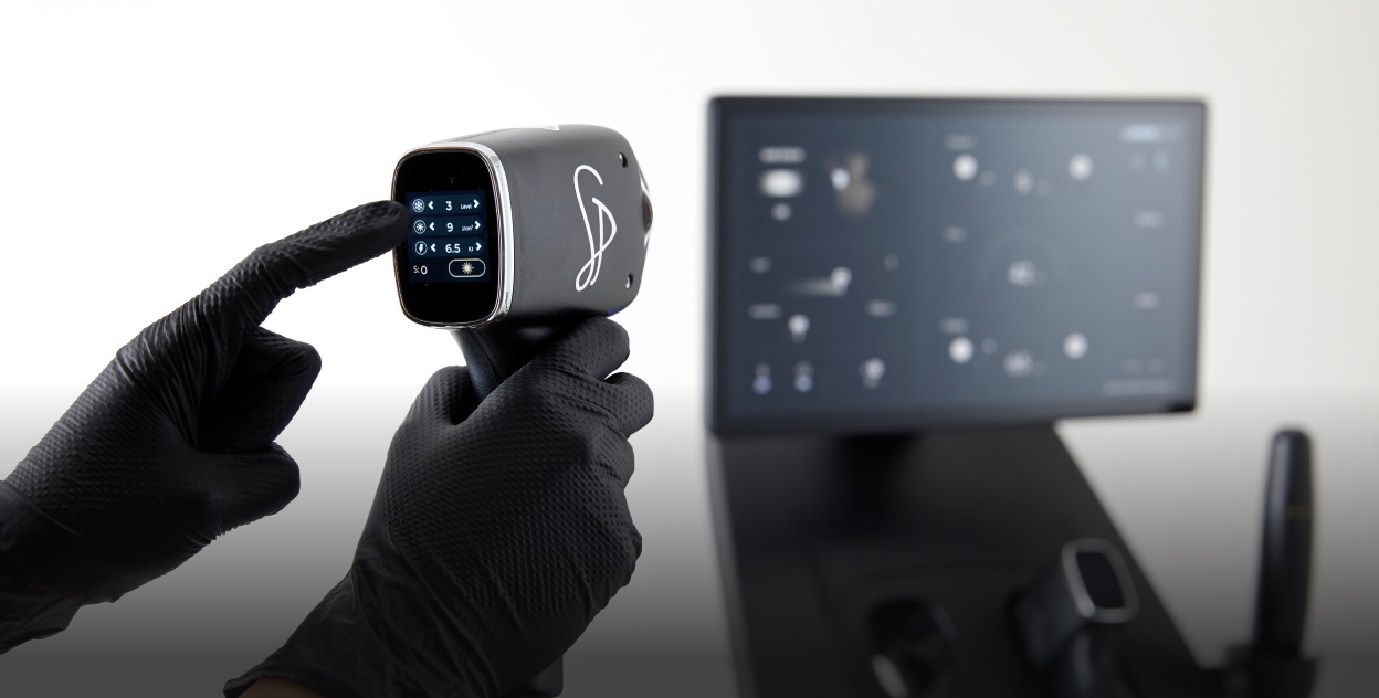 Lumière Elite triple-wavelength laser machine and handpiece in use