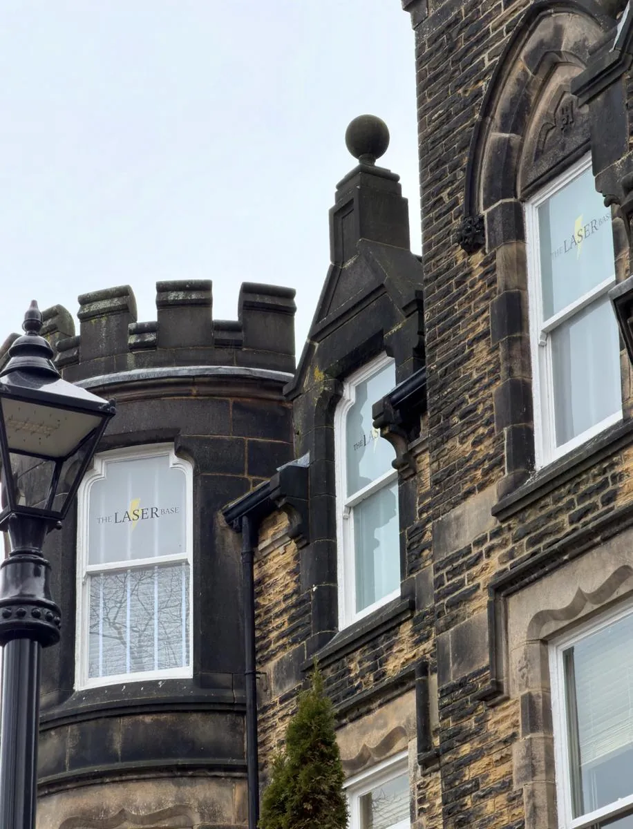 The stone frontage of the Harrogate clinic with The Laser Base window signage