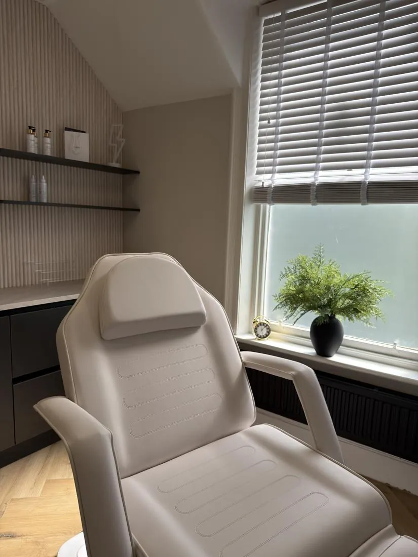 Treatment bed beside a bright sash window with shelving