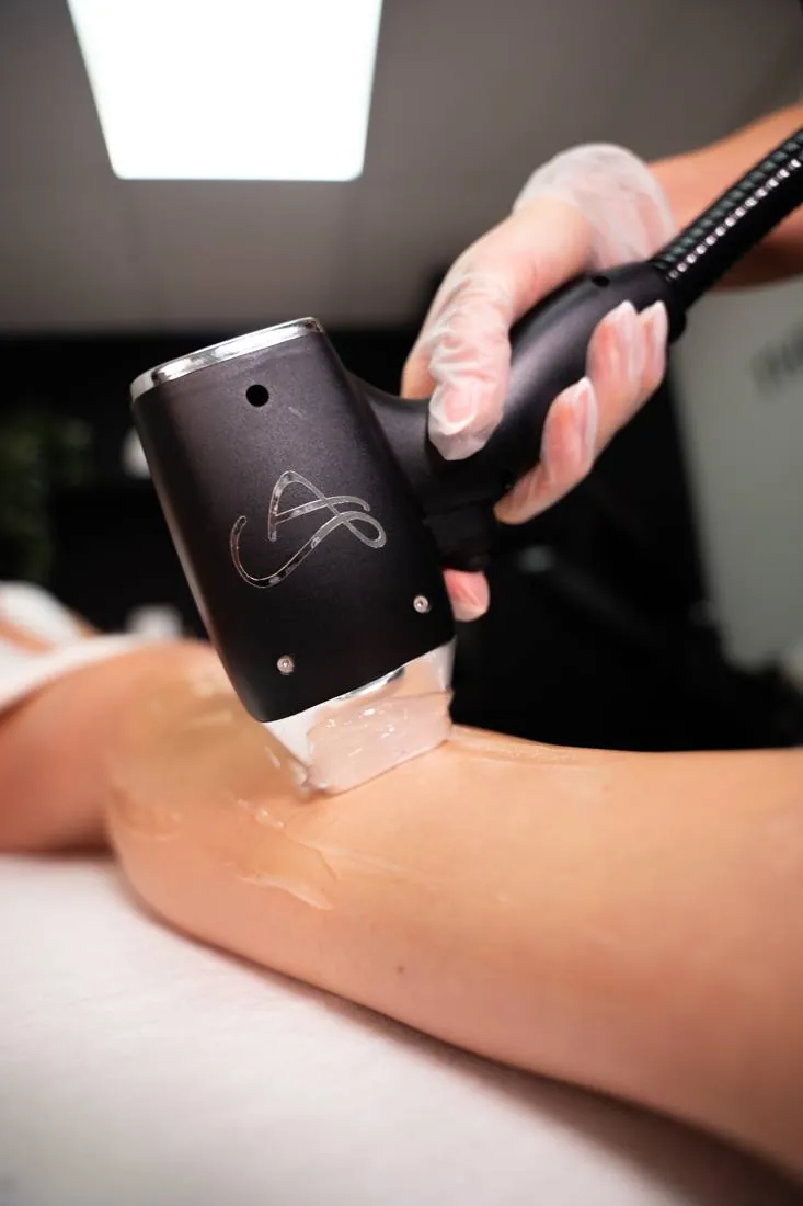 The Lumiere Elite handpiece treating a leg with cooling gel applied