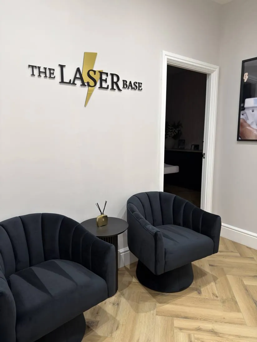 Reception area with The Laser Base signage and velvet armchairs